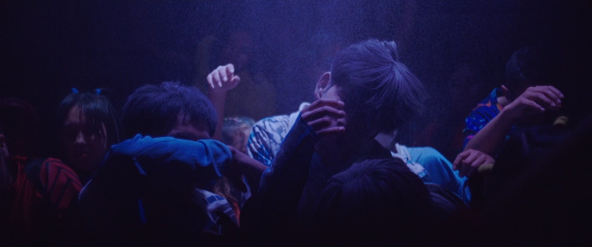 Still de 4EBER: jóvenes bailando en una discoteca bajo luz azul y violeta